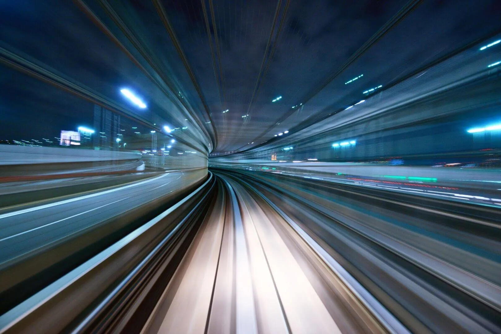 Long-exposure view along a lit tunnel, the walls blurred into streaks of speed