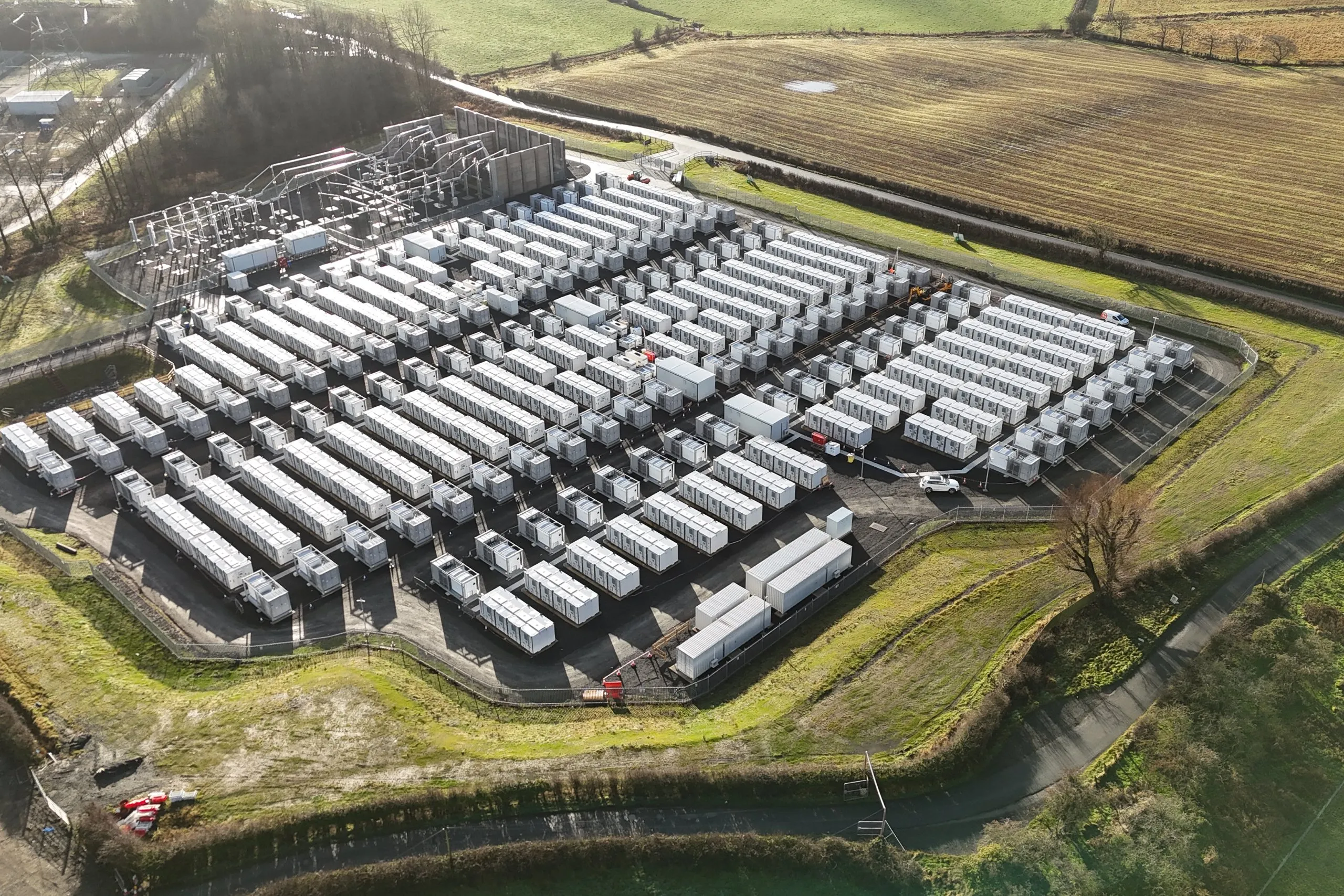 Aerial view of a battery energy storage site surrounded by farmland.